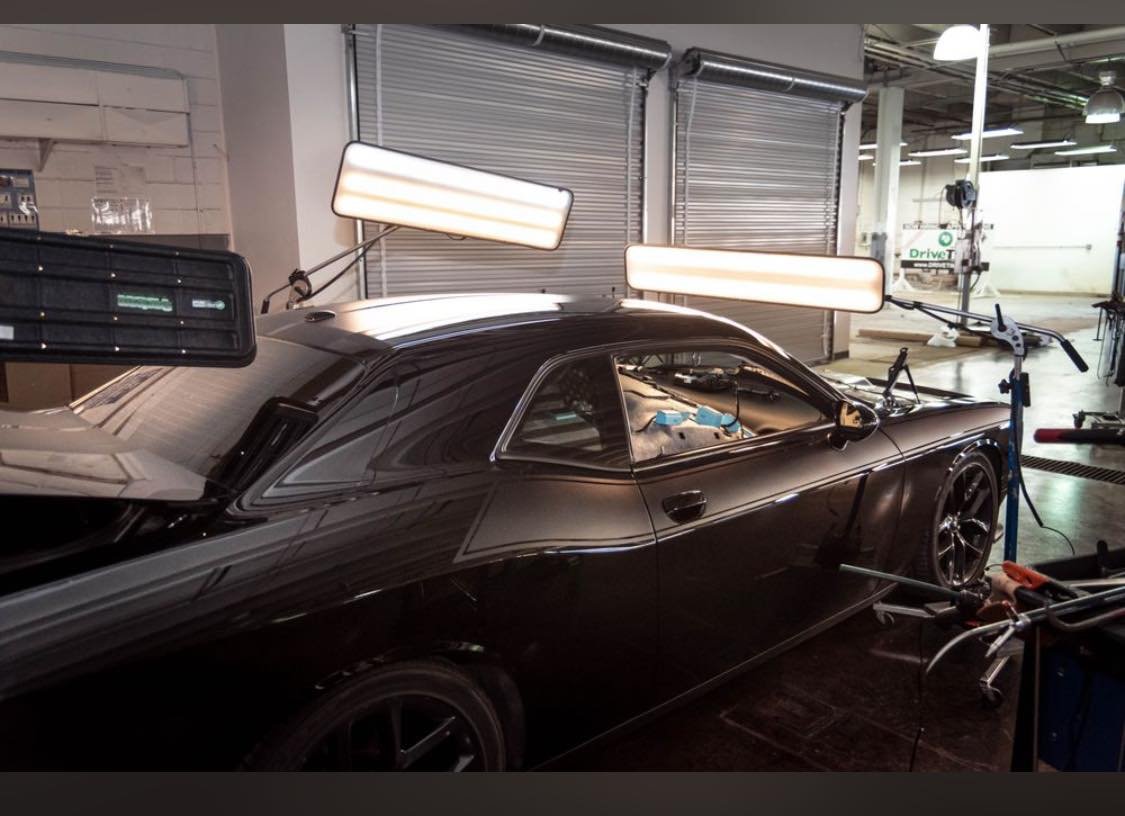 Vehicle being repaired with paintless dent repair lighting